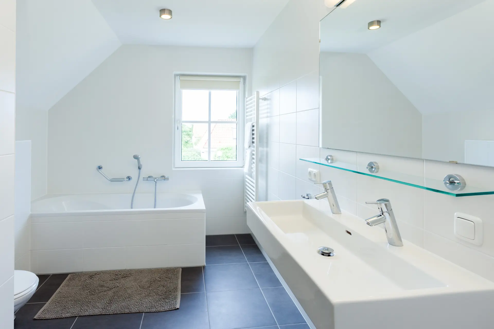 Badkamer op verdieping met bad, douche, toilet en wastafel